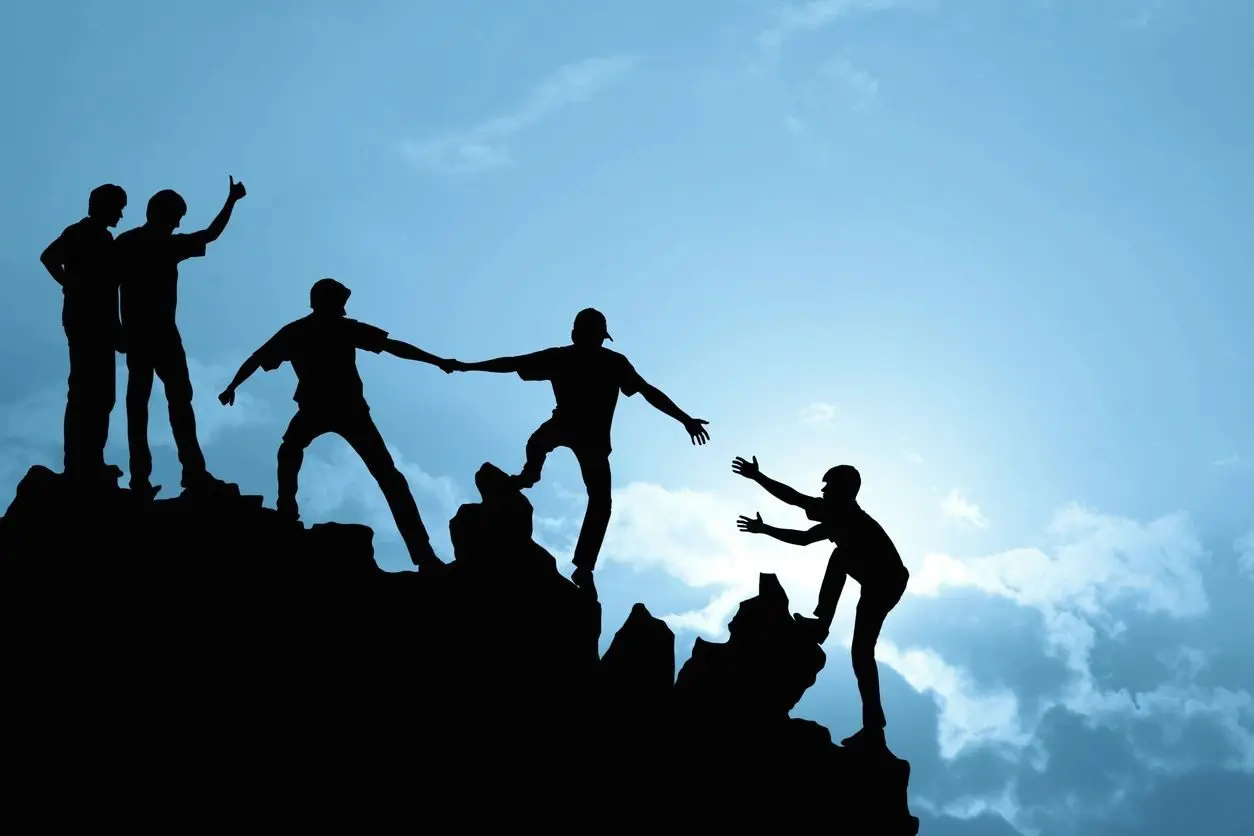 A group of people climbing up the side of a mountain.