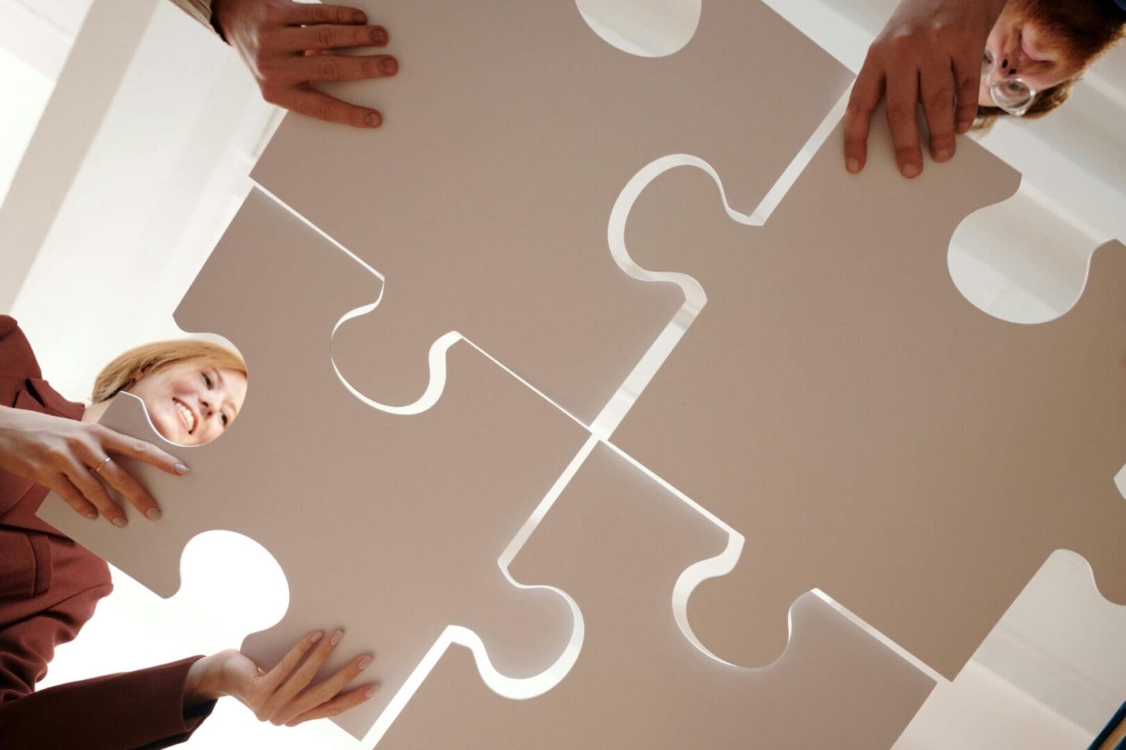 A group of people holding up puzzle pieces.